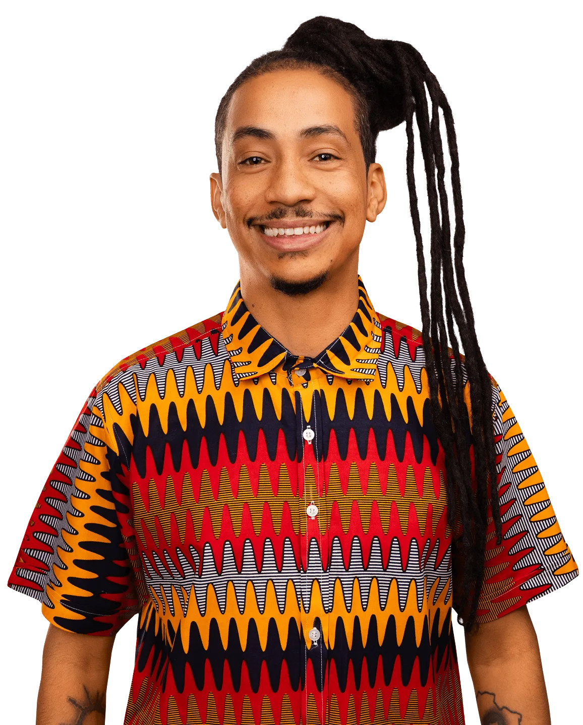 Matheus Gomes sorrindo, de camisa estampada em tons de laranja e vermelho